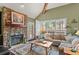 Cozy living room with a stone fireplace and serene forest views at 29857 Park Village Dr, Evergreen, CO 80439