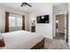 Bedroom with large window, ceiling fan and TV features a bathroom with dual sinks and a glass enclosed shower at 4184 Kalamath St, Denver, CO 80211