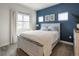 Bright bedroom features a stylish blue accent wall, light wood furnishings, and natural light from a large window at 4184 Kalamath St, Denver, CO 80211