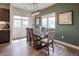 A dining room with wood table, six chairs, modern lighting fixture and view of adjacent buildings through the windows at 4184 Kalamath St, Denver, CO 80211