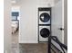 Hallway features a stacked washer and dryer in an alcove and provides access to a modern primary bedroom at 4184 Kalamath St, Denver, CO 80211