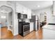 Well-lit kitchen featuring modern stainless steel appliances and white cabinetry at 2075 Oakland St, Aurora, CO 80010