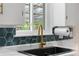 Close-up of modern kitchen sink with gold faucet and white cabinets at 2075 Oakland St, Aurora, CO 80010