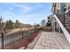 Backyard view overlooking the green space, with stone patio and black iron fencing at 9099 Prairie Sky Ln, Lone Tree, CO 80124