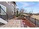 Backyard featuring a stone patio, retaining wall, and black iron fencing at 9099 Prairie Sky Ln, Lone Tree, CO 80124