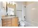 A bright bathroom with wood cabinets, granite countertops, and a tile shower at 9099 Prairie Sky Ln, Lone Tree, CO 80124