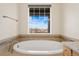 Well-lit soaking tub featuring a neighborhood view from the expansive window above at 9099 Prairie Sky Ln, Lone Tree, CO 80124