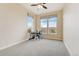 Bright bedroom with three windows, neutral carpeting, and a desk area offers a versatile and comfortable space at 9099 Prairie Sky Ln, Lone Tree, CO 80124