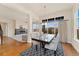 Bright dining area with a modern table, stylish chairs, and large windows offering neighborhood views and a fireplace at 9099 Prairie Sky Ln, Lone Tree, CO 80124