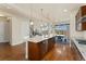 Bright, open kitchen with a large center island, stainless appliances, and hardwood floors flowing into the dining area at 9099 Prairie Sky Ln, Lone Tree, CO 80124