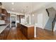 Spacious kitchen with hardwood floors, a central island, and stainless steel appliances offers seamless flow to the staircase at 9099 Prairie Sky Ln, Lone Tree, CO 80124