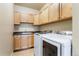 Laundry room with white appliances, ample storage, and neutral tile flooring at 9099 Prairie Sky Ln, Lone Tree, CO 80124