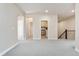 Open-concept living space with neutral walls and carpet leading to more rooms at 9099 Prairie Sky Ln, Lone Tree, CO 80124