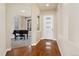 Inviting entryway with hardwood floors leading to a cozy room featuring a piano and a large window at 9099 Prairie Sky Ln, Lone Tree, CO 80124