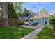 Inviting backyard with patio furniture, grill, and lush green lawn surrounded by a wooden fence at 2527 W Dunkeld Pl, Denver, CO 80211