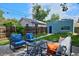 Inviting backyard with patio furniture, grill, and lush green lawn surrounded by a wooden fence at 2527 W Dunkeld Pl, Denver, CO 80211