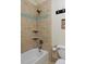 Bright bathroom with beige tile shower, blue accent stripe, and modern fixtures at 2527 W Dunkeld Pl, Denver, CO 80211