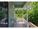 Comfortable front porch seating area with views of lush greenery and shade trees at 2527 W Dunkeld Pl, Denver, CO 80211