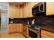 Modern kitchen features granite countertops, wooden cabinets, and stainless steel appliances at 2527 W Dunkeld Pl, Denver, CO 80211