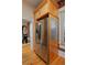 Kitchen featuring stainless steel refrigerator and wooden cabinets, with views into dining and living area at 2527 W Dunkeld Pl, Denver, CO 80211
