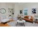 Cozy living room featuring modern decor, a leather sofa, and a decorative corner shelf at 2527 W Dunkeld Pl, Denver, CO 80211