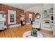 Bright living room with exposed brick, a modern chair, and open access to the dining area at 2527 W Dunkeld Pl, Denver, CO 80211