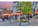 Charming outdoor seating area with orange umbrellas, lush greenery, and quaint signage at a local restaurant at 2527 W Dunkeld Pl, Denver, CO 80211