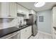 Updated kitchen featuring stainless steel appliances, black countertops, and white cabinets at 4940 E Donald Ave # 8, Denver, CO 80222