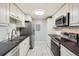 A modern kitchen with white cabinetry, stainless steel appliances, and sleek black countertops at 4940 E Donald Ave # 8, Denver, CO 80222