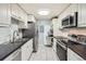 A modern kitchen with white cabinetry, stainless steel appliances, and sleek black countertops at 4940 E Donald Ave # 8, Denver, CO 80222