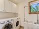Functional laundry room equipped with white washer, dryer, storage cabinets, and a folding area at 3135 11Th St, Boulder, CO 80304