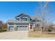 Charming two-story home with a three-car garage and stone accents against a clear blue sky at 543 Springvale Rd, Castle Rock, CO 80104