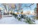 Snowy backyard with trees and deck at 6990 Orchard Ct, Arvada, CO 80007