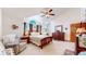 Large bedroom with a comfortable seating area and ceiling fan at 6990 Orchard Ct, Arvada, CO 80007