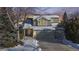 Two-story house exterior, snow-covered, with a two-car garage at dusk at 6990 Orchard Ct, Arvada, CO 80007