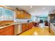 Galley kitchen with wood cabinets, granite countertops, and stainless steel appliances at 6990 Orchard Ct, Arvada, CO 80007