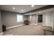 Finished basement with gray carpet, a brown papasan chair, and a view into another room at 12606 S Sopris Creek Dr, Parker, CO 80134
