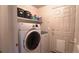 Well-equipped laundry room featuring front load washer and dryer, storage shelf, and door to exterior at 12606 S Sopris Creek Dr, Parker, CO 80134