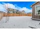 Snow-covered backyard includes wood fence and view of neighboring houses in the community at 14769 Dahlia St, Thornton, CO 80602