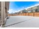 Backyard featuring a full fence, snow, and neighboring homes in the community at 14769 Dahlia St, Thornton, CO 80602