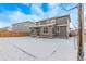 Back exterior view with a snow covered yard, patio, fencing, and multi-story home at 14769 Dahlia St, Thornton, CO 80602