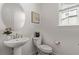 Bathroom featuring a modern floating sink, an elegant round mirror, and neutral wall tones at 14769 Dahlia St, Thornton, CO 80602