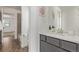 Modern bathroom with gray vanity, a white countertop, tile flooring, and bathtub at 14769 Dahlia St, Thornton, CO 80602