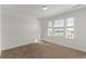 An empty bedroom has three windows with outside views at 14769 Dahlia St, Thornton, CO 80602