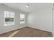 A minimalist bedroom featuring carpet flooring and three large windows at 14769 Dahlia St, Thornton, CO 80602