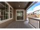 Covered patio includes sliding glass doors, string lights, wood floors and outdoor railing at 14769 Dahlia St, Thornton, CO 80602