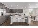 Modern kitchen features gray cabinets, stainless steel appliances, a center island, and bar stool seating at 14769 Dahlia St, Thornton, CO 80602