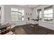 Bright office space featuring three large windows and modern decor on dark, hardwood floors at 14769 Dahlia St, Thornton, CO 80602