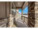 Covered porch with stone pillars, offering outdoor space and neighborhood views in winter at 14769 Dahlia St, Thornton, CO 80602