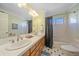 Bathroom with double sinks, bathtub, and shower at 13471 Cascade St, Broomfield, CO 80020